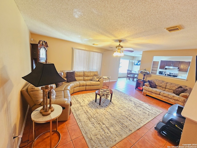 tiled living room with ceiling fan and a textured ceiling