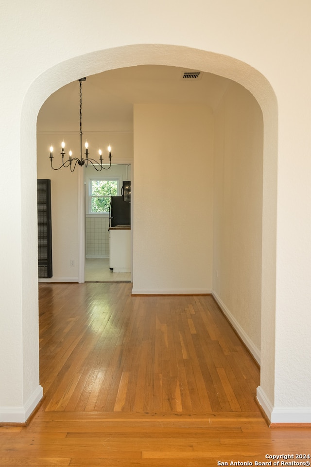 interior space featuring hardwood / wood-style flooring and a notable chandelier