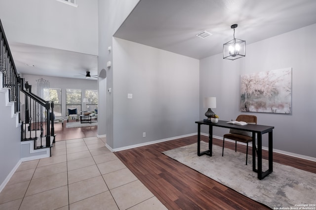 foyer entrance with light hardwood / wood-style flooring and ceiling fan with notable chandelier