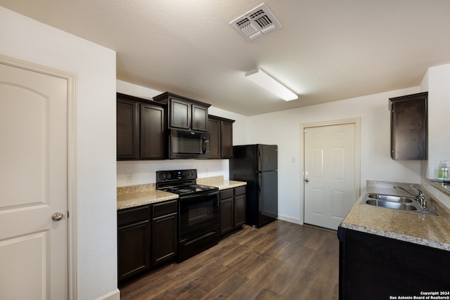 kitchen with dark hardwood / wood-style flooring, a textured ceiling, dark brown cabinetry, sink, and black appliances