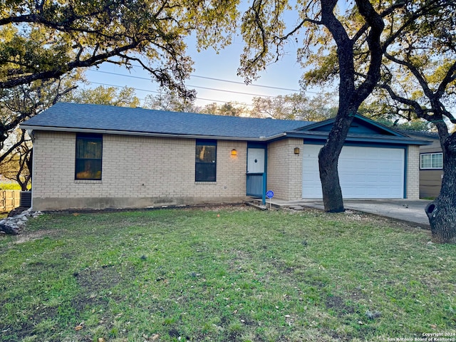 ranch-style home featuring a garage and a front lawn