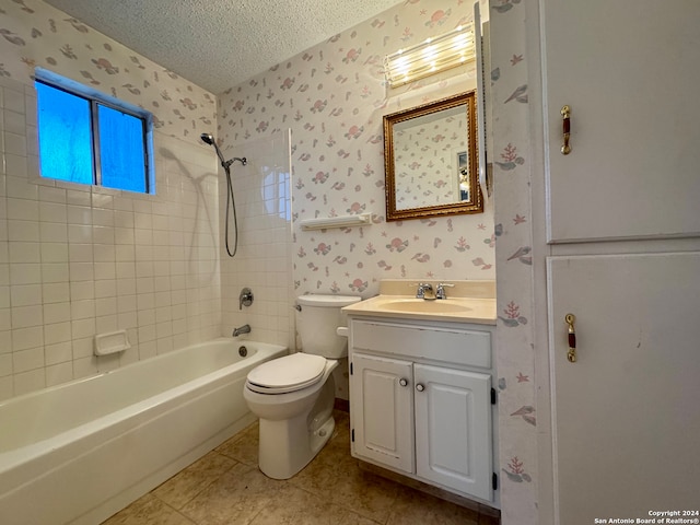 full bathroom featuring vanity, tile patterned floors, tiled shower / bath combo, toilet, and a textured ceiling