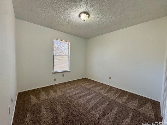 carpeted spare room featuring a textured ceiling