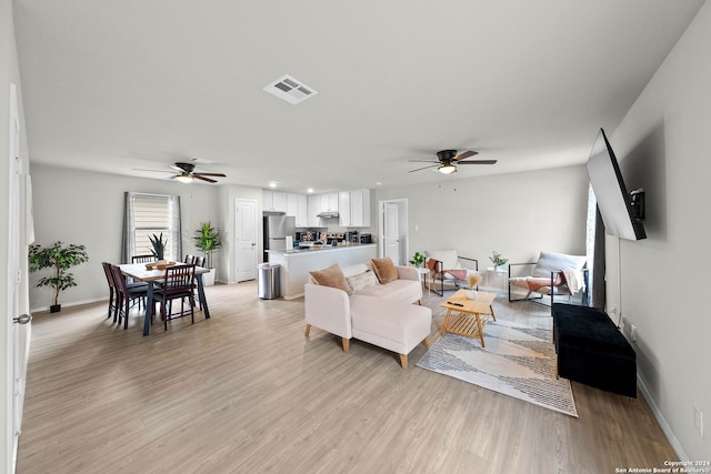 living room with ceiling fan and light hardwood / wood-style floors