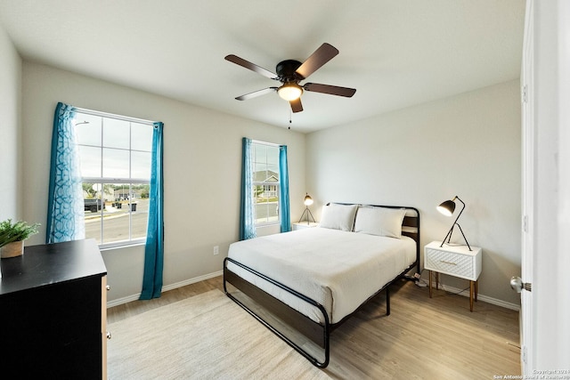 bedroom featuring light hardwood / wood-style flooring, multiple windows, and ceiling fan