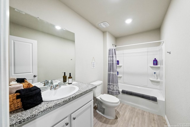 full bathroom with hardwood / wood-style floors, vanity, shower / tub combo, and toilet