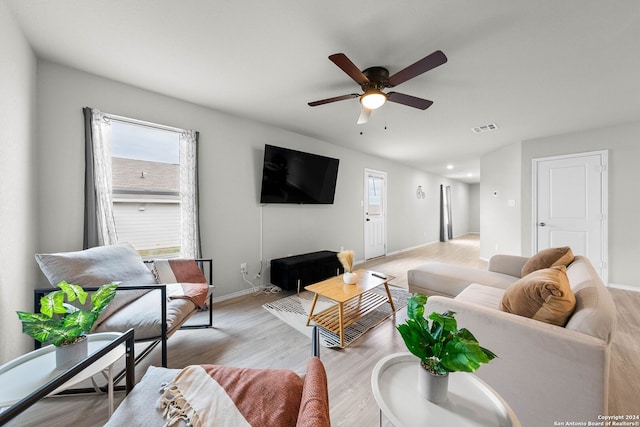 living room with ceiling fan and light hardwood / wood-style flooring