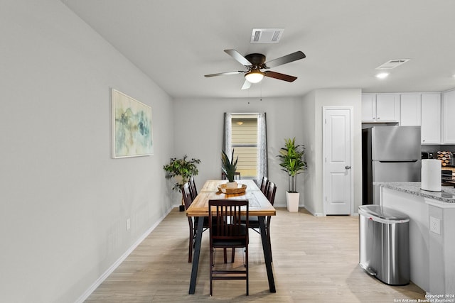 dining space with ceiling fan and light wood-type flooring