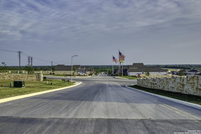 view of road featuring street lighting and curbs