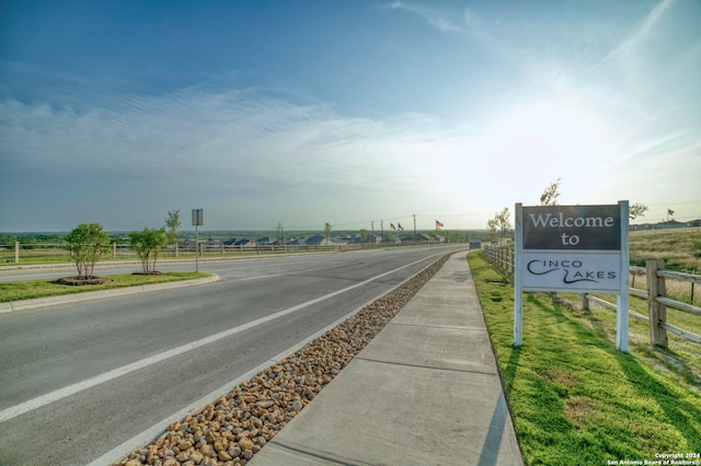 view of street featuring a rural view and sidewalks