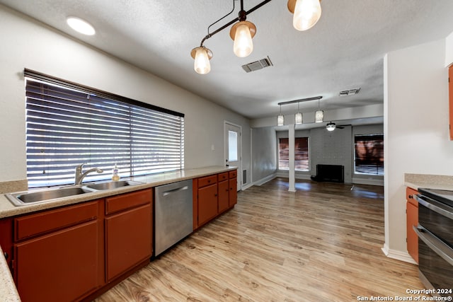 kitchen featuring hanging light fixtures, sink, light wood-type flooring, and appliances with stainless steel finishes