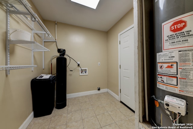 laundry area with light tile patterned flooring, hookup for a washing machine, and water heater