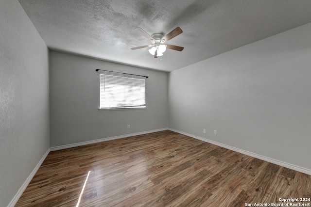 unfurnished room featuring ceiling fan, dark hardwood / wood-style flooring, and a textured ceiling