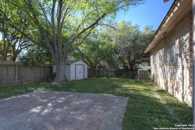 view of yard with a patio, a shed, and central AC unit