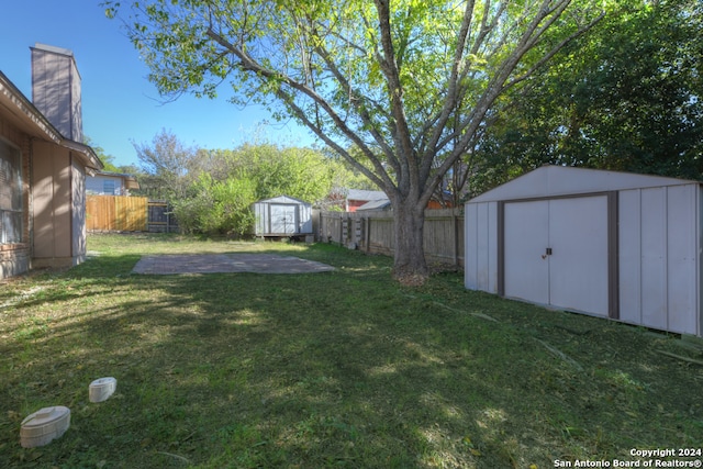 view of yard featuring a storage unit and a patio