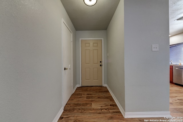 doorway to outside featuring wood-type flooring and a textured ceiling