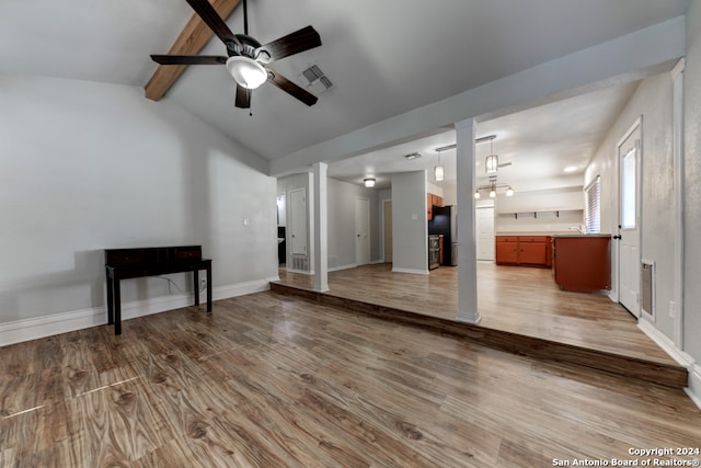 unfurnished living room featuring vaulted ceiling with beams, light wood-type flooring, and ceiling fan