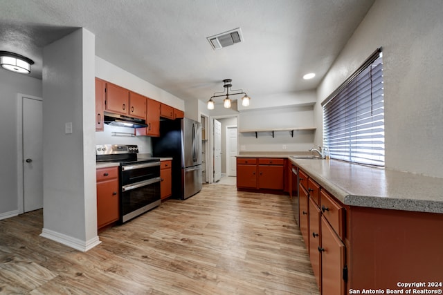 kitchen featuring sink, light hardwood / wood-style flooring, a textured ceiling, and appliances with stainless steel finishes