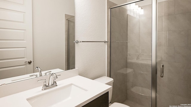 bathroom featuring walk in shower, vanity, and toilet