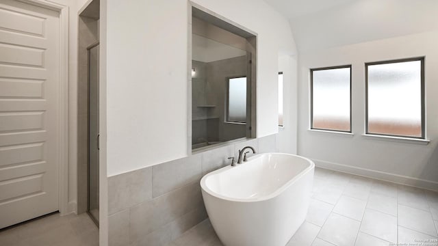 bathroom featuring tile patterned floors, separate shower and tub, and tile walls