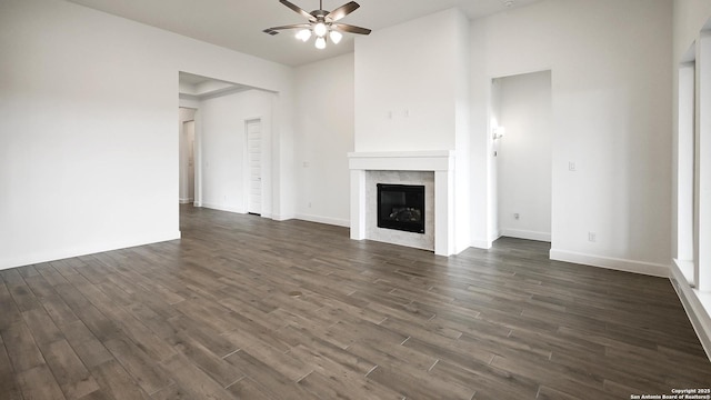 unfurnished living room with a tile fireplace, dark hardwood / wood-style floors, and ceiling fan