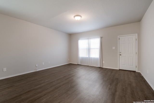 spare room featuring dark wood-type flooring