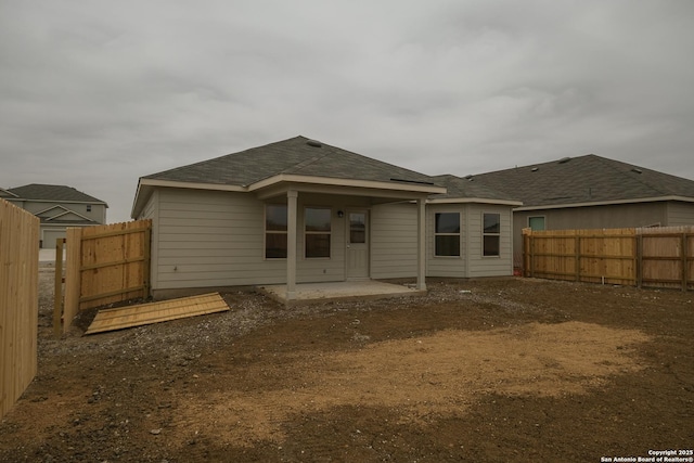 back of property with a patio area and a fenced backyard