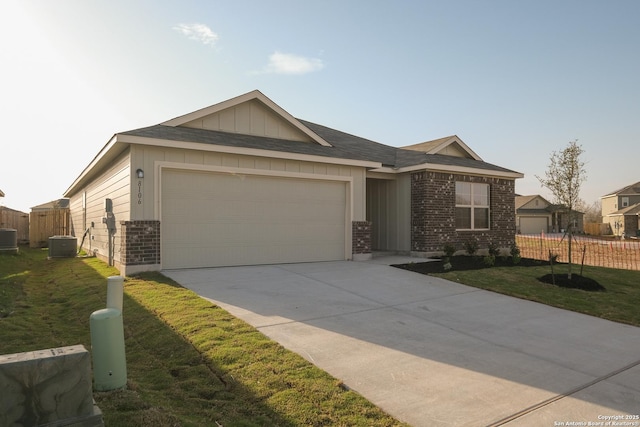 ranch-style house featuring fence, board and batten siding, a front yard, an attached garage, and brick siding