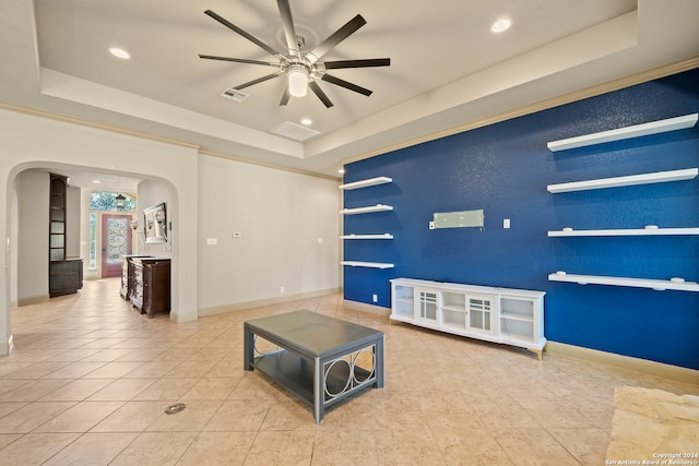 living room featuring light tile patterned floors, a raised ceiling, and ceiling fan