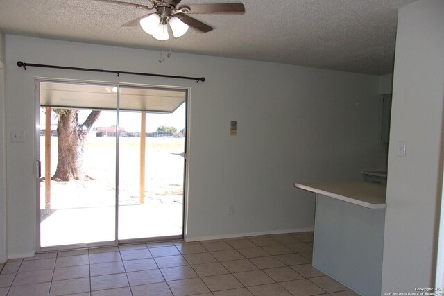 608 Val Verde Dr, Pleasanton, TX 78064 - unfurnished dining area featuring a ceiling fan, a textured ceiling, light tile patterned flooring, and baseboards