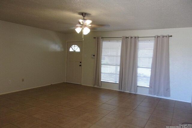 608 Val Verde Dr, Pleasanton, TX 78064 - spare room featuring ceiling fan, a textured ceiling, light tile patterned floors, and baseboards