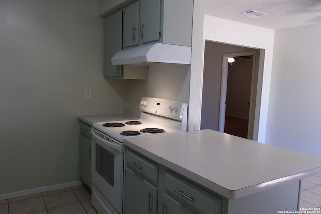 kitchen with a textured ceiling, light tile patterned flooring, electric stove, and kitchen peninsula