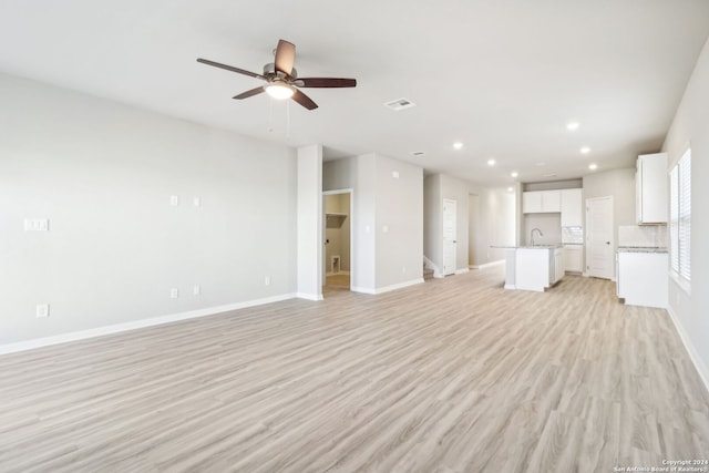 unfurnished living room with light hardwood / wood-style flooring and ceiling fan