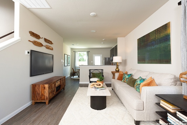 living room with dark hardwood / wood-style flooring and a textured ceiling