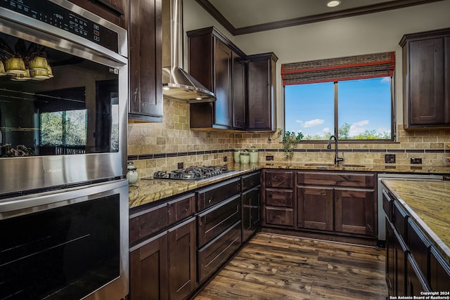 kitchen with wall chimney range hood, sink, dark hardwood / wood-style floors, appliances with stainless steel finishes, and light stone counters