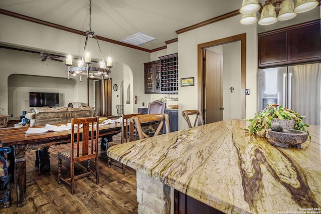 dining space featuring ceiling fan with notable chandelier, dark wood-type flooring, and crown molding