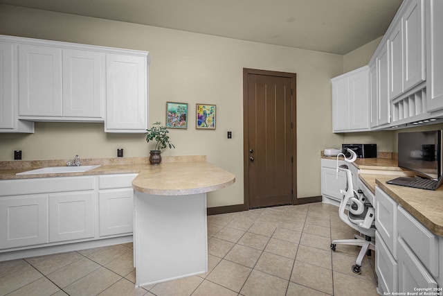 laundry area featuring light tile patterned floors and sink