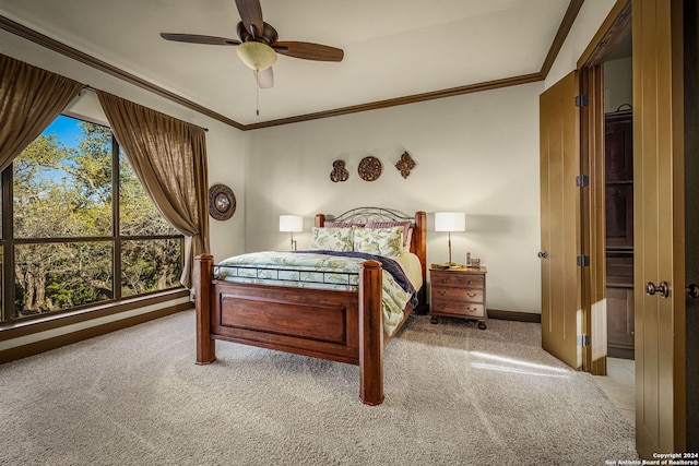 carpeted bedroom with ceiling fan and ornamental molding