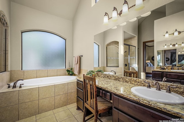 bathroom featuring tile patterned floors, vanity, vaulted ceiling, and independent shower and bath