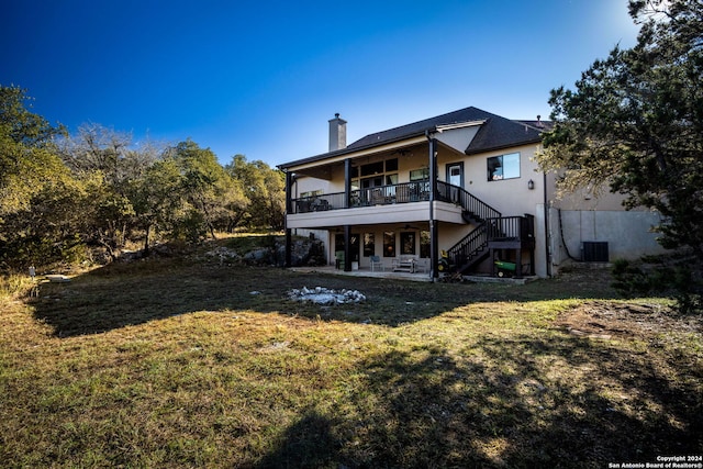 back of property with a lawn, ceiling fan, and a patio