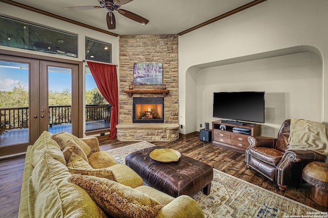 living room featuring french doors, ceiling fan, ornamental molding, a fireplace, and dark hardwood / wood-style flooring