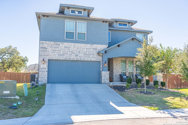 view of front of house featuring cooling unit, a garage, and a front yard