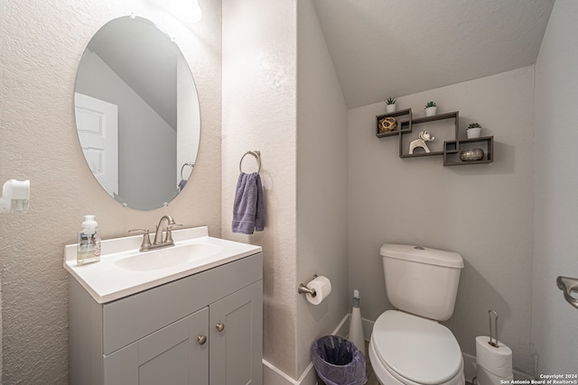 bathroom with toilet, a textured ceiling, vanity, and vaulted ceiling