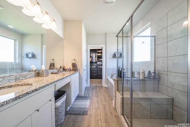 bathroom with hardwood / wood-style flooring, vanity, and shower with separate bathtub