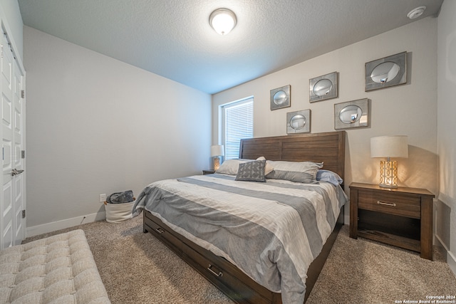 carpeted bedroom featuring lofted ceiling and a textured ceiling