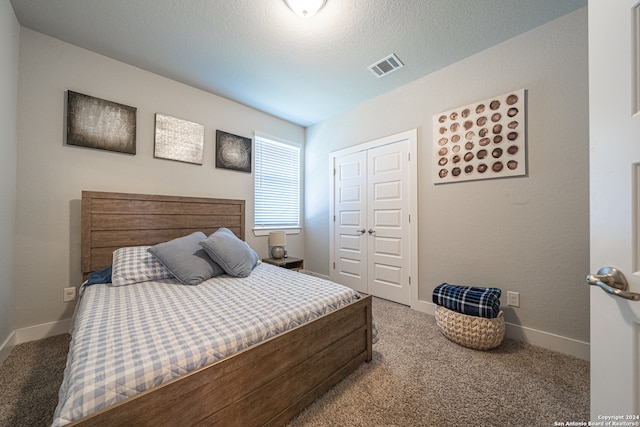 bedroom featuring a closet, carpet, and a textured ceiling