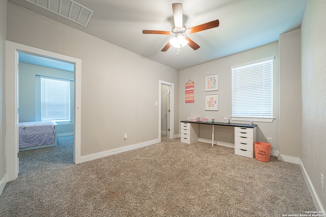 unfurnished office featuring ceiling fan and carpet