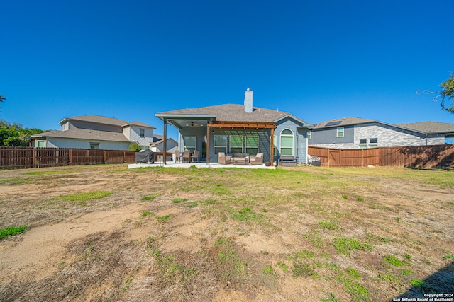 rear view of house with a patio and a lawn