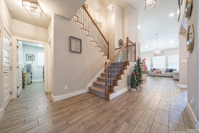 stairway with an inviting chandelier and hardwood / wood-style flooring