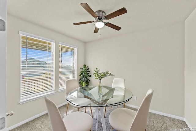 carpeted dining area featuring ceiling fan